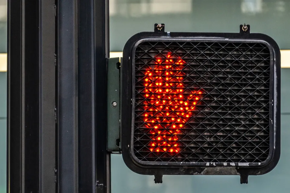 Red hand lit up as "don't walk" pedestrian signal.